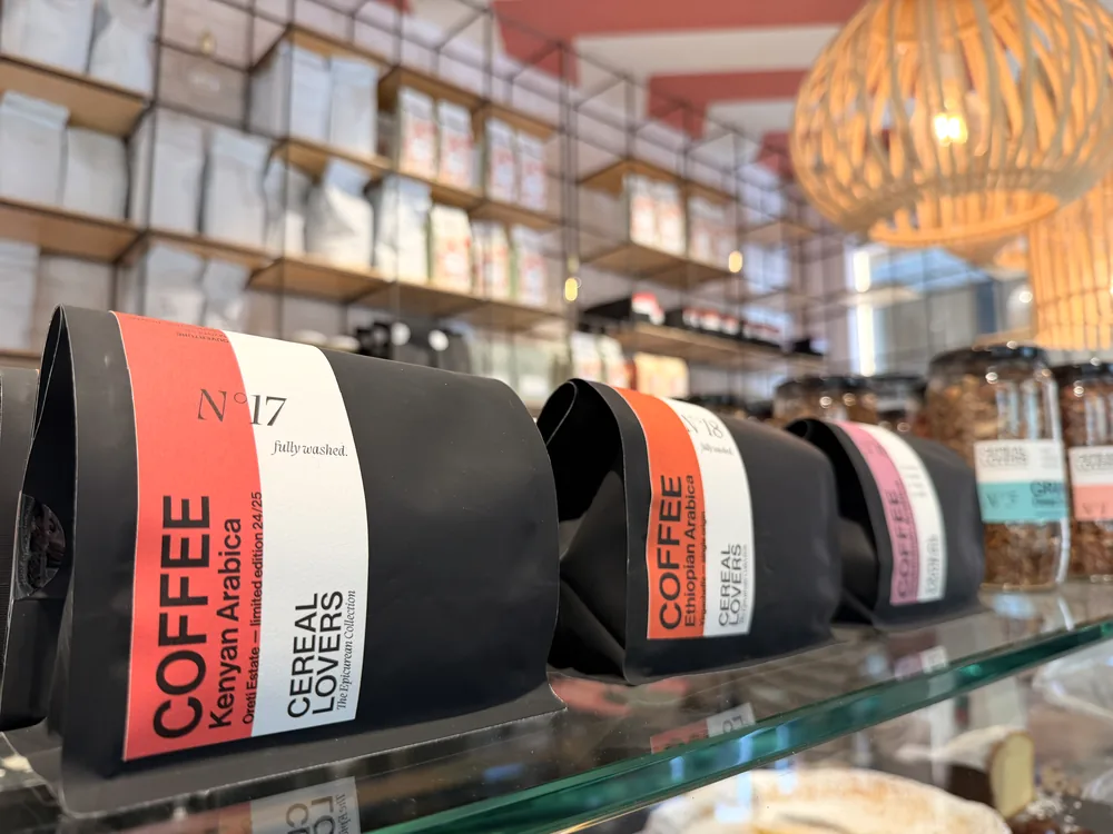 Coffee bags N°17, N°18 and N°16 on the glass counter under the wicker lamp