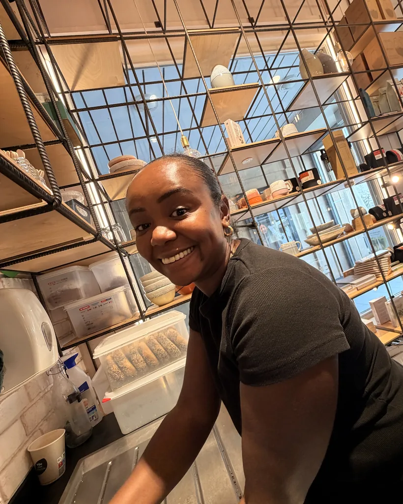 A team member grinning at the sink behind the bar